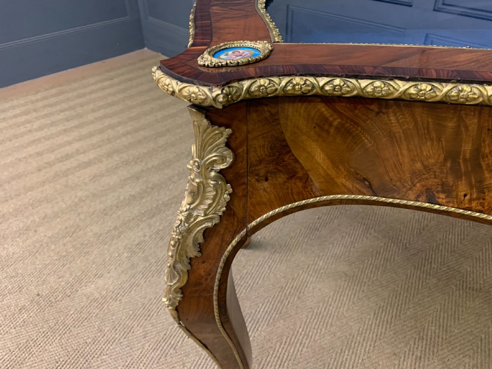 A 19th-century French Louis XV style bijouterie table with a glazed display top, curved cabriole legs, gilt bronze mounts, porcelain plaques, and a blue velvet interior. View XIV