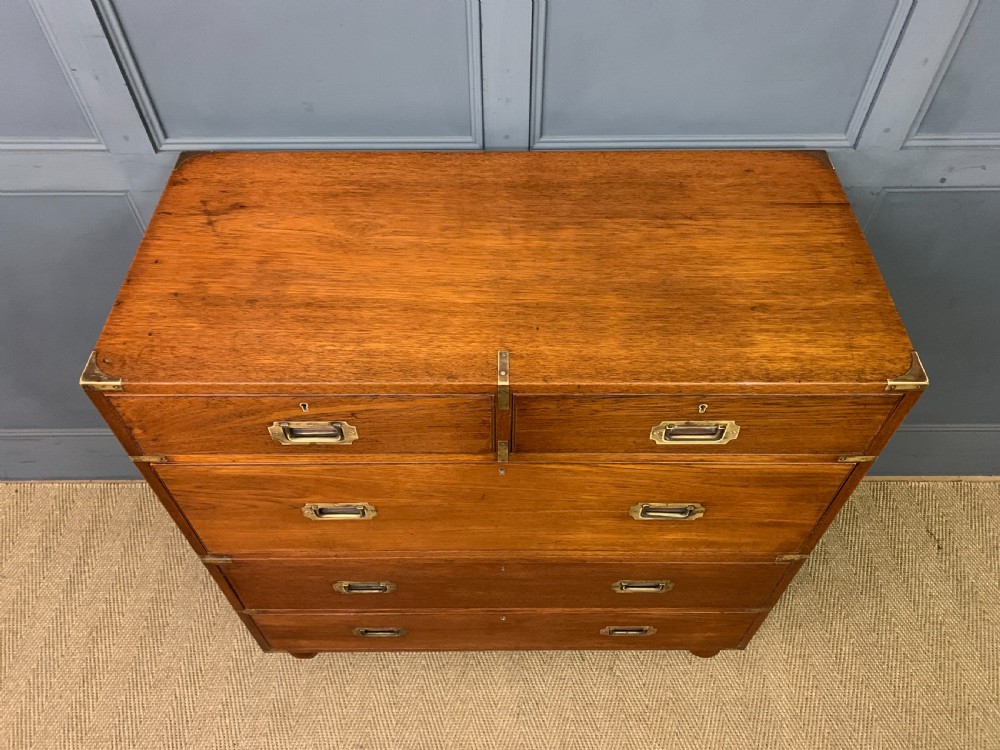 A Victorian teak two-part military campaign chest featuring flush brass handles, brass corner brackets, and turned legs. View IV