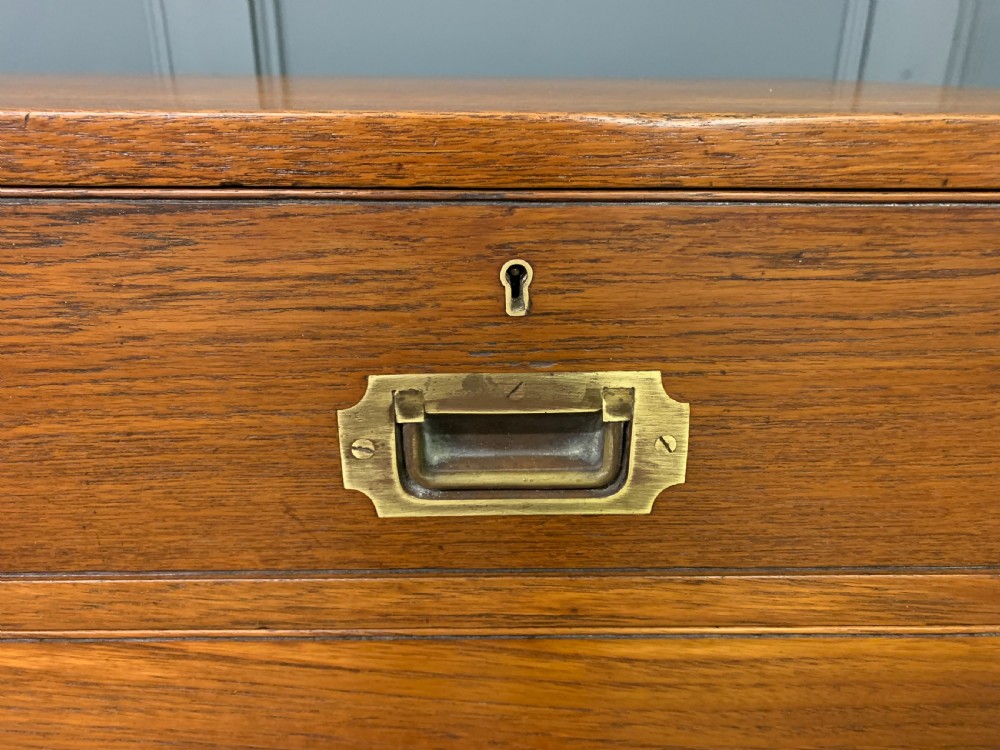 A Victorian teak two-part military campaign chest featuring flush brass handles, brass corner brackets, and turned legs. View VI