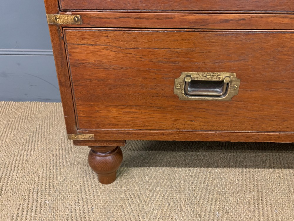 A Victorian teak two-part military campaign chest featuring flush brass handles, brass corner brackets, and turned legs. View VII
