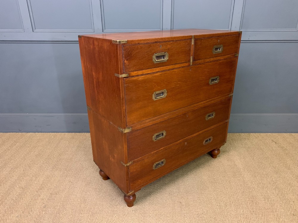 A Victorian teak two-part military campaign chest featuring flush brass handles, brass corner brackets, and turned legs. View IX