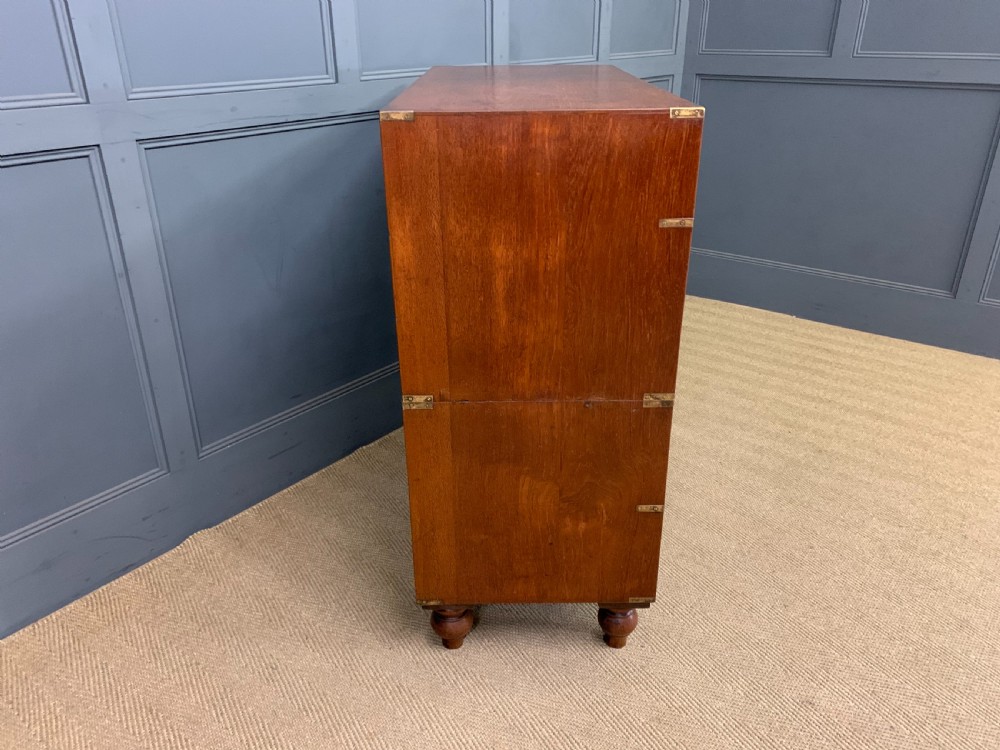 A Victorian teak two-part military campaign chest featuring flush brass handles, brass corner brackets, and turned legs. View X