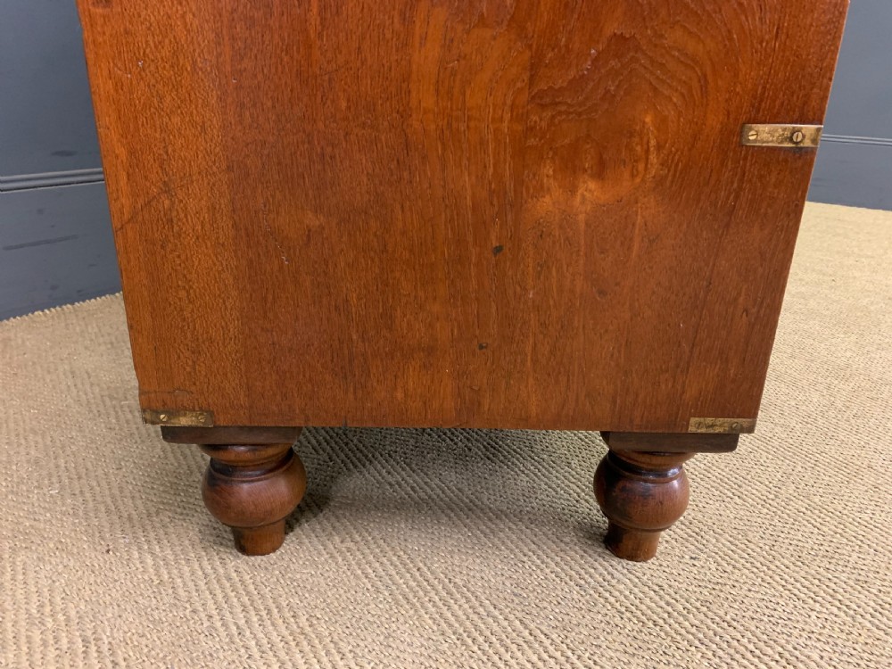 A Victorian teak two-part military campaign chest featuring flush brass handles, brass corner brackets, and turned legs. View XI