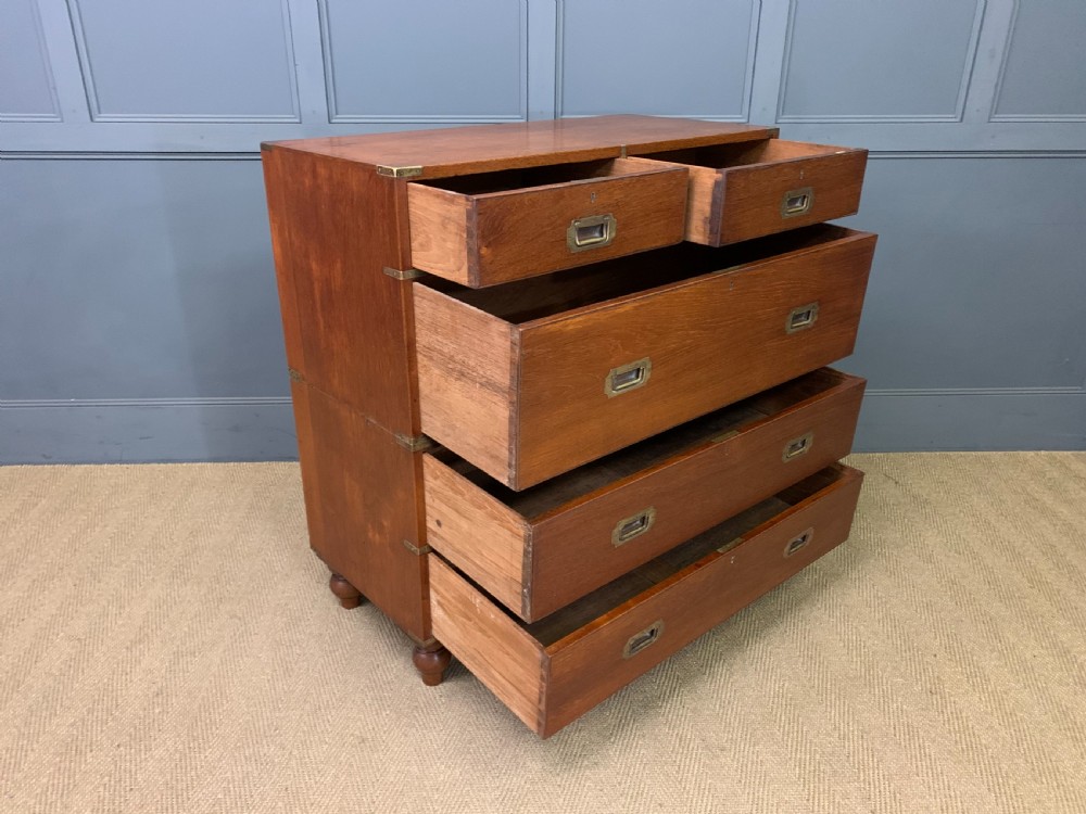 A Victorian teak two-part military campaign chest featuring flush brass handles, brass corner brackets, and turned legs. View XII