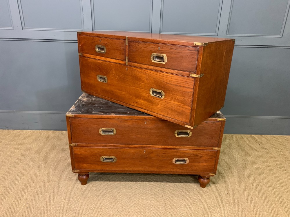 A Victorian teak two-part military campaign chest featuring flush brass handles, brass corner brackets, and turned legs. View XVI