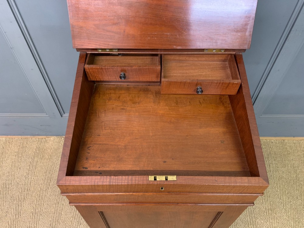 A George IV mahogany Davenport desk featuring a slanted brown leather writing surface, brass gallery rail, four side drawers with turned knobs, and bun feet. View X