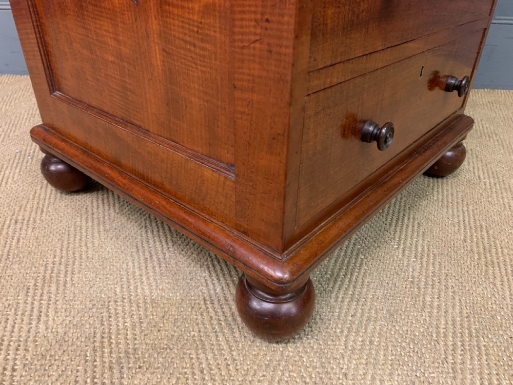 A George IV mahogany Davenport desk featuring a slanted brown leather writing surface, brass gallery rail, four side drawers with turned knobs, and bun feet. View XX