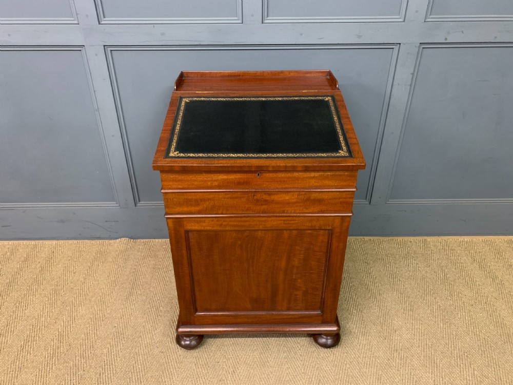 An early Victorian mahogany Davenport desk with a sloped leather writing surface and side drawers. View II