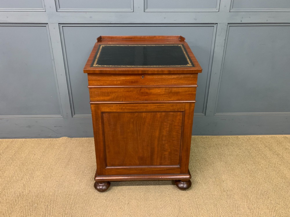 An early Victorian mahogany Davenport desk with a sloped leather writing surface and side drawers. View III