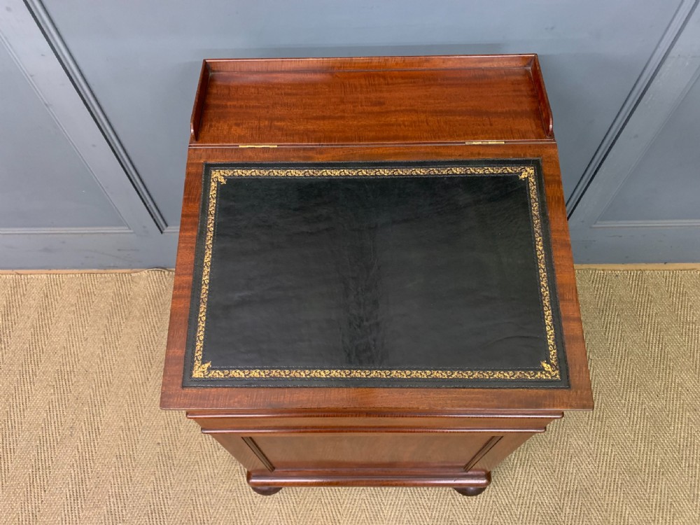 An early Victorian mahogany Davenport desk with a sloped leather writing surface and side drawers. View V