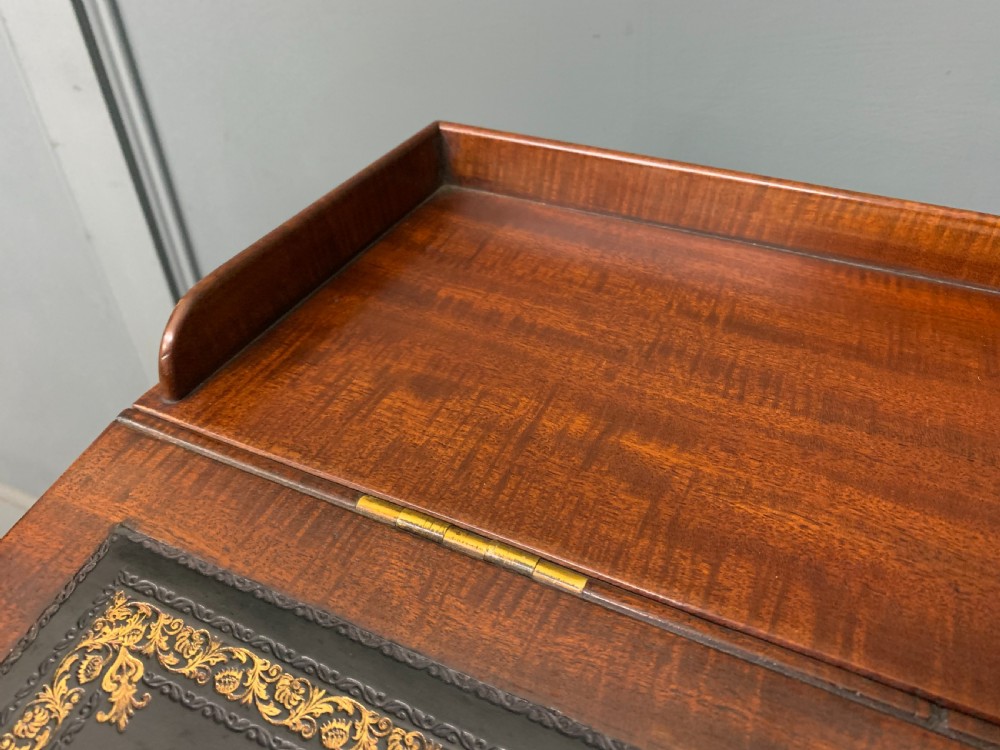 An early Victorian mahogany Davenport desk with a sloped leather writing surface and side drawers. View VI