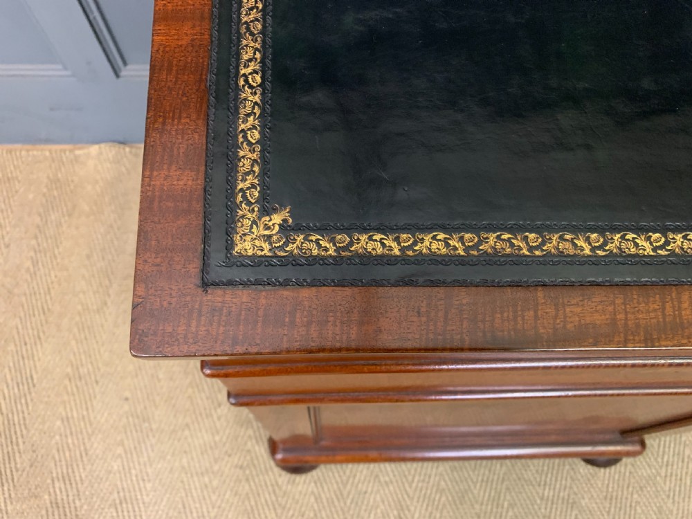 An early Victorian mahogany Davenport desk with a sloped leather writing surface and side drawers. View VII