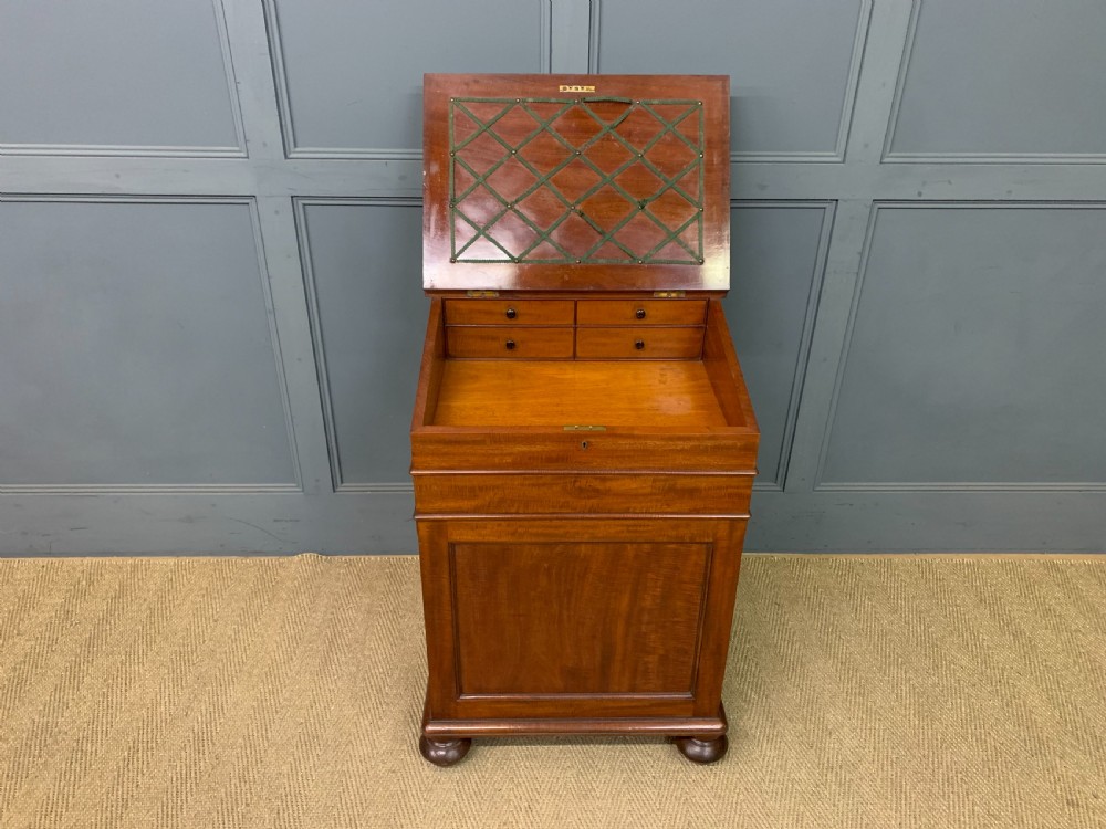 An early Victorian mahogany Davenport desk with a sloped leather writing surface and side drawers. View VIII