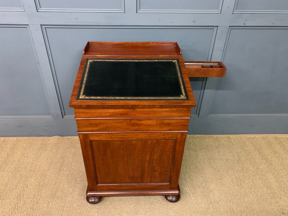 An early Victorian mahogany Davenport desk with a sloped leather writing surface and side drawers. View XII