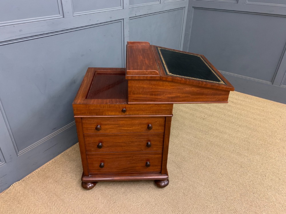 An early Victorian mahogany Davenport desk with a sloped leather writing surface and side drawers. View XIII