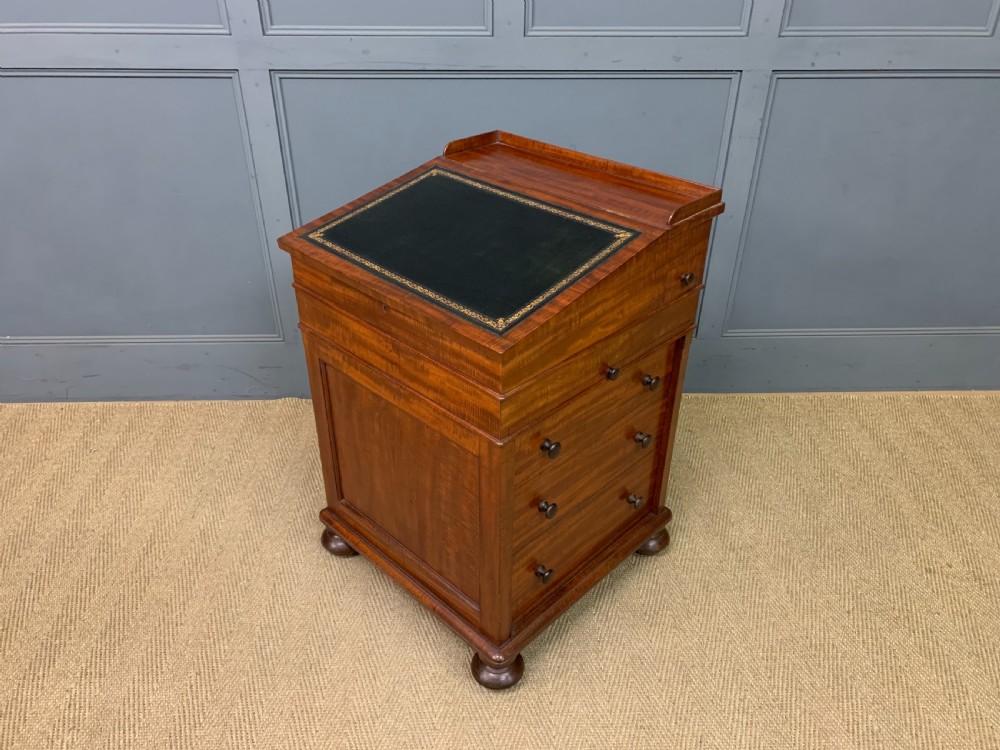 An early Victorian mahogany Davenport desk with a sloped leather writing surface and side drawers. View XXIII