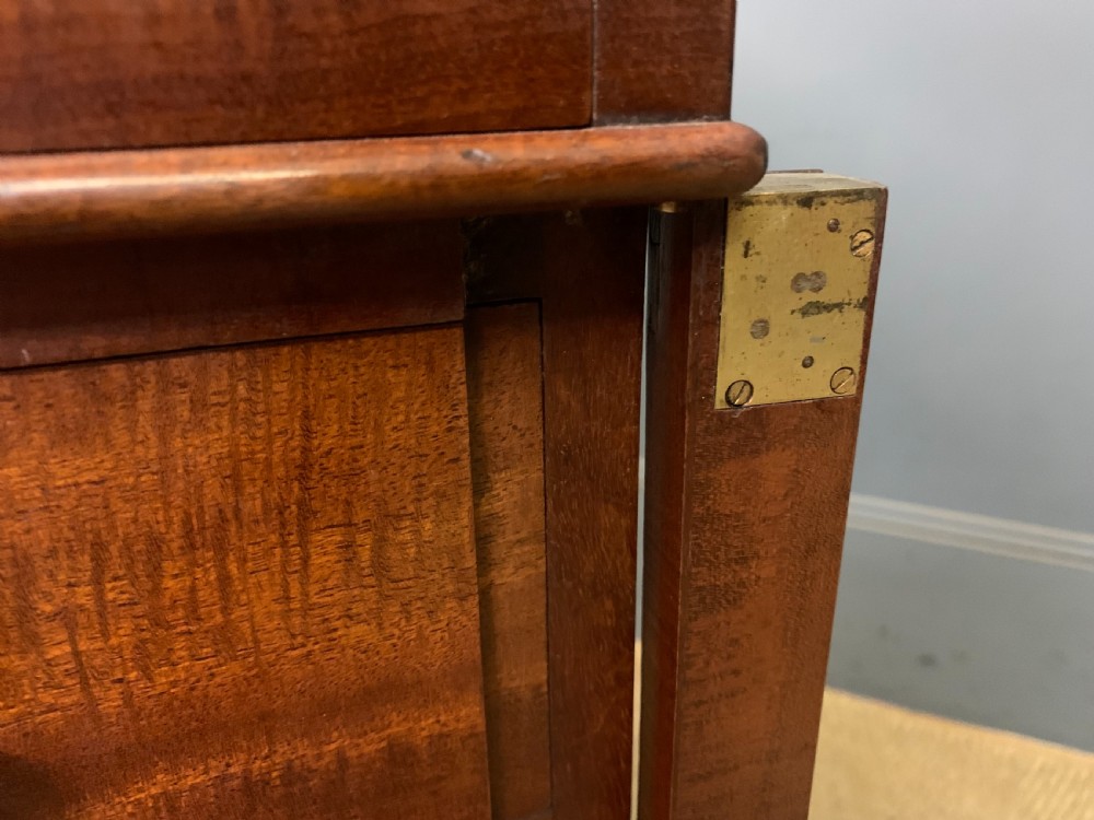 An early Victorian mahogany Davenport desk with a sloped leather writing surface and side drawers. View XXVI