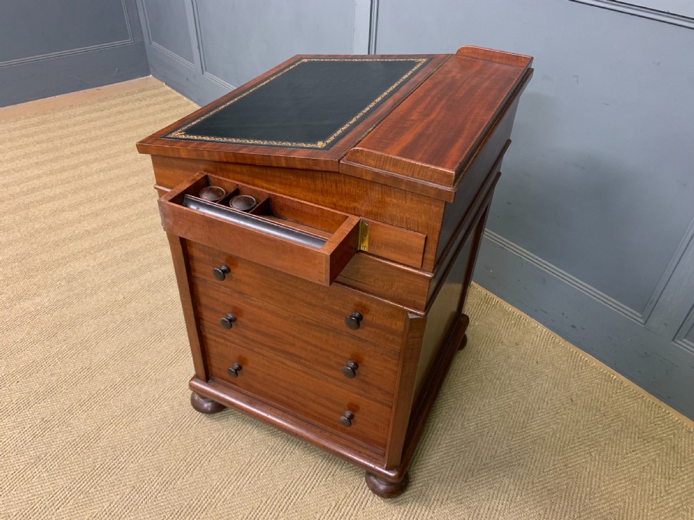 An early Victorian mahogany Davenport desk with a sloped leather writing surface and side drawers. View XXIX