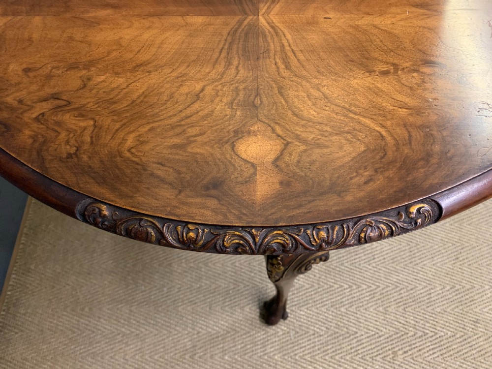 A burr walnut drop flap table featuring carved cabriole legs with leaf decoration, a single drawer with brass pull, and two rounded drop leaves. View IX