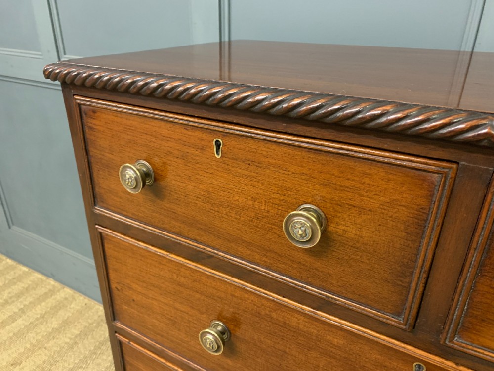 A George IV mahogany chest of drawers featuring two short over three long drawers with turned knobs, brass escutcheons, and rope-twist edge moulding. View III