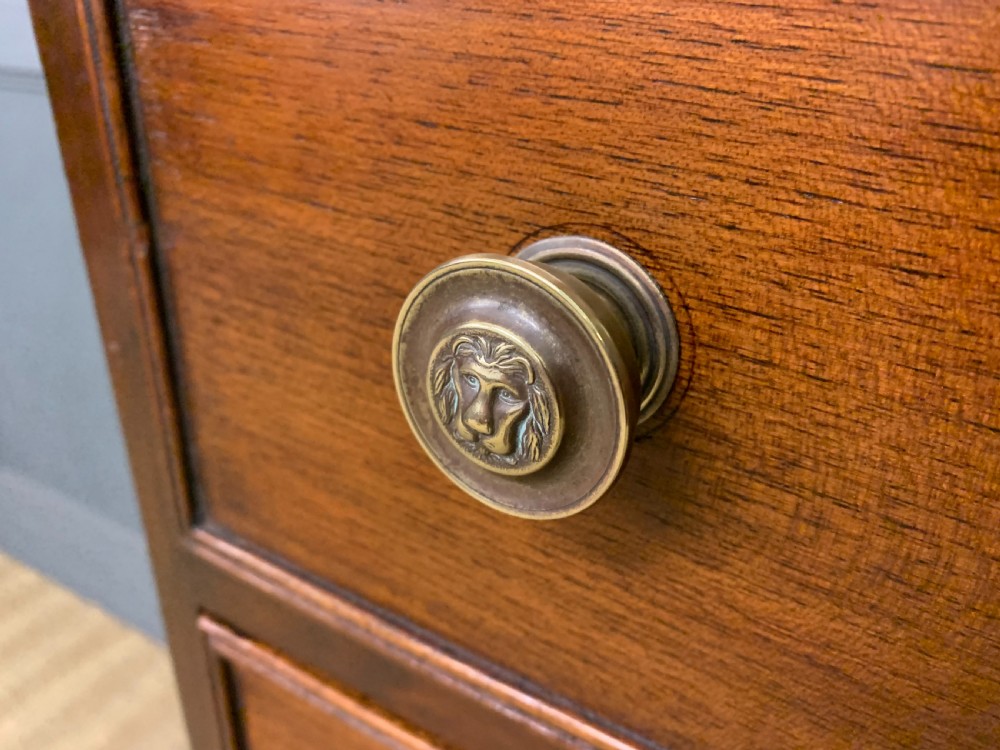 A George IV mahogany chest of drawers featuring two short over three long drawers with turned knobs, brass escutcheons, and rope-twist edge moulding. View IV