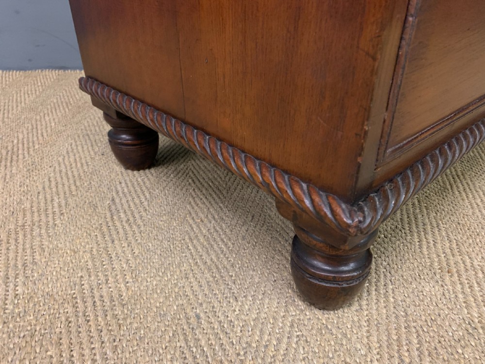 A George IV mahogany chest of drawers featuring two short over three long drawers with turned knobs, brass escutcheons, and rope-twist edge moulding. View IX