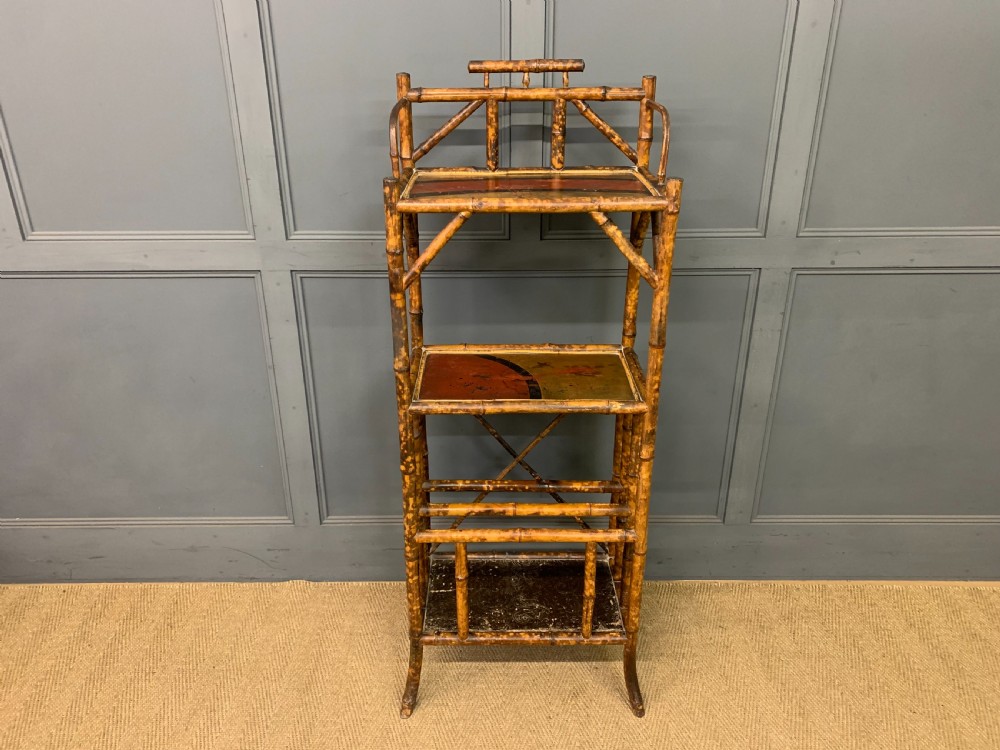 A late Victorian three-tiered bamboo whatnot stand featuring lacquer wood panel surfaces and vertical lower divisions. View II