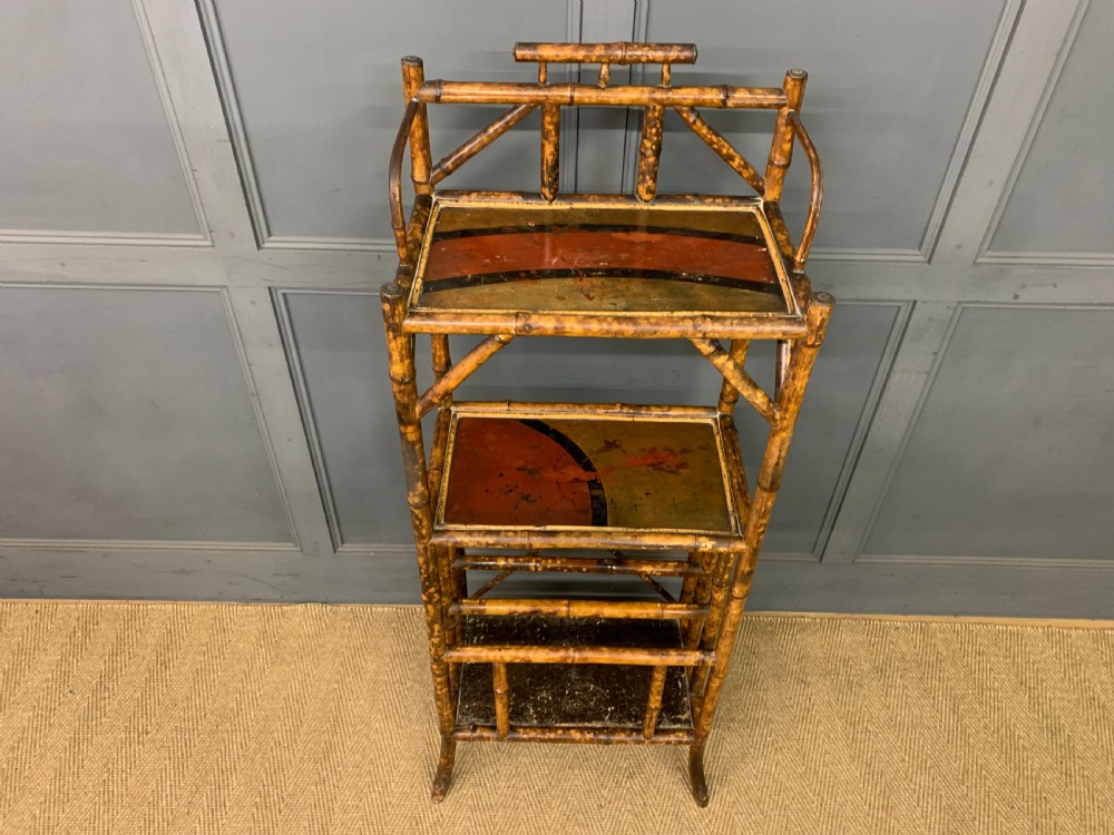 A late Victorian three-tiered bamboo whatnot stand featuring lacquer wood panel surfaces and vertical lower divisions. View III