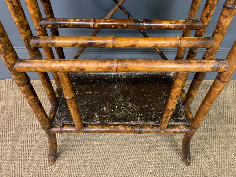 A late Victorian three-tiered bamboo whatnot stand featuring lacquer wood panel surfaces and vertical lower divisions. View V