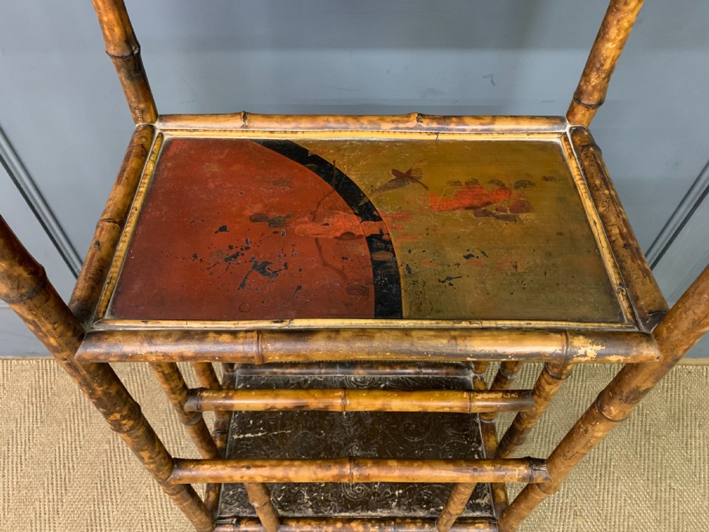 A late Victorian three-tiered bamboo whatnot stand featuring lacquer wood panel surfaces and vertical lower divisions. View VI