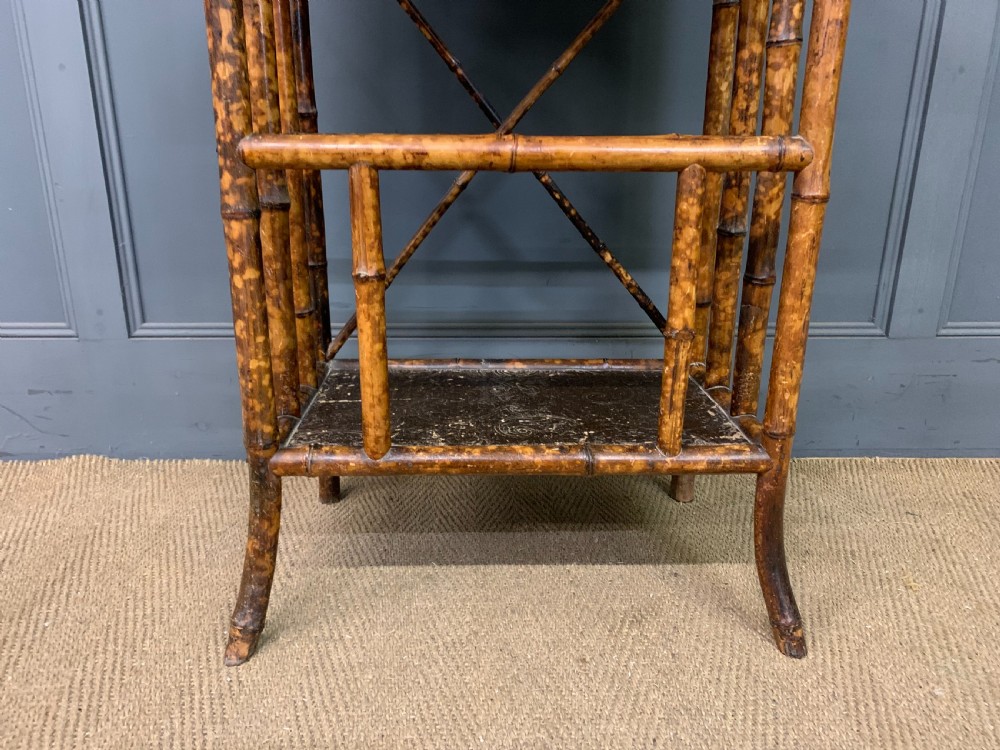 A late Victorian three-tiered bamboo whatnot stand featuring lacquer wood panel surfaces and vertical lower divisions. View IX