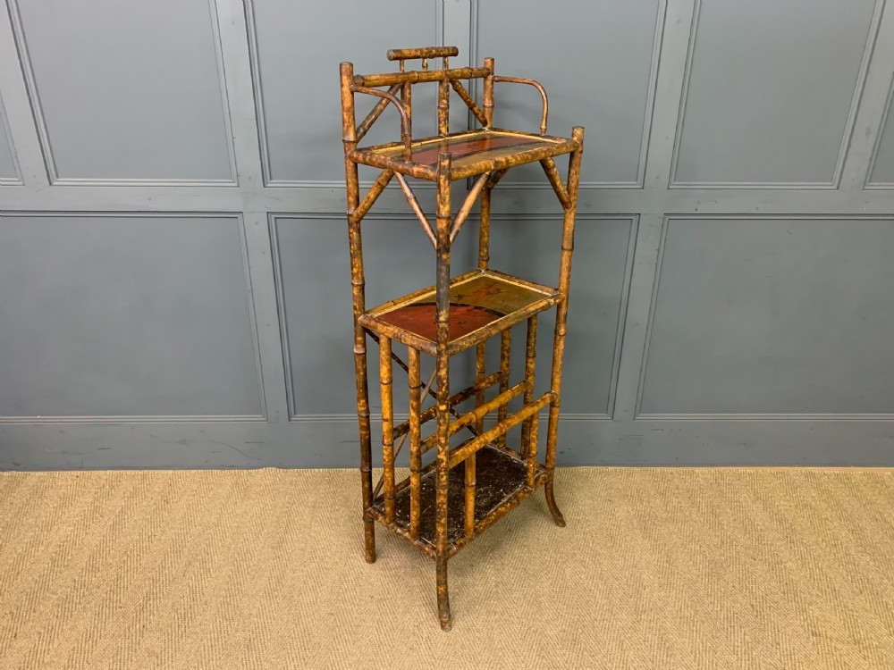 A late Victorian three-tiered bamboo whatnot stand featuring lacquer wood panel surfaces and vertical lower divisions. View X