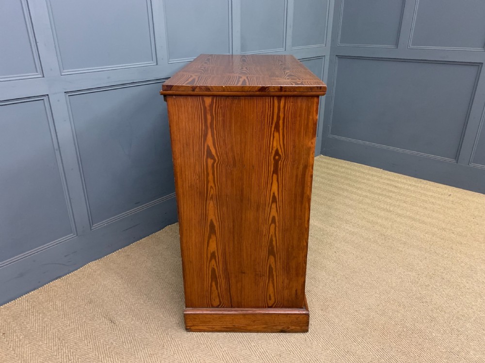 A late Victorian pitch pine chest of drawers featuring ebonised geometric dot inlay details and brass drop handles. View IX