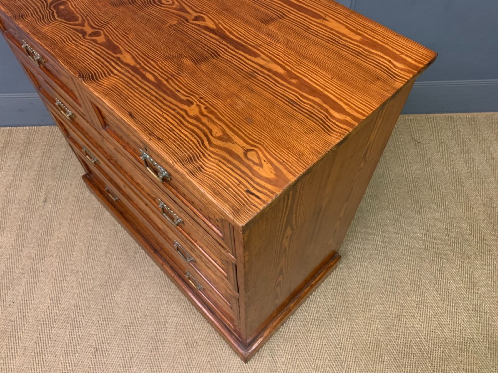 A late Victorian pitch pine chest of drawers featuring ebonised geometric dot inlay details and brass drop handles. View XII