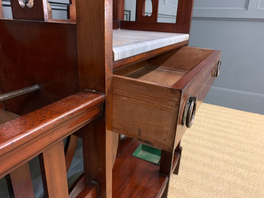 An Arts and Crafts inlaid mahogany hall stand featuring an arched central mirror, coat pegs, marble surface, and integrated umbrella racks. View VIII