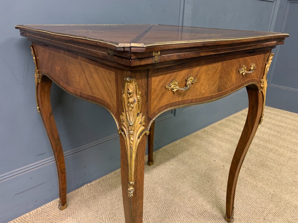 An Edwardian inlaid rosewood envelope card table featuring cabriole legs with brass mounts, a single drawer, and top flaps decorated with floral and musical instrument marquetry. View VII