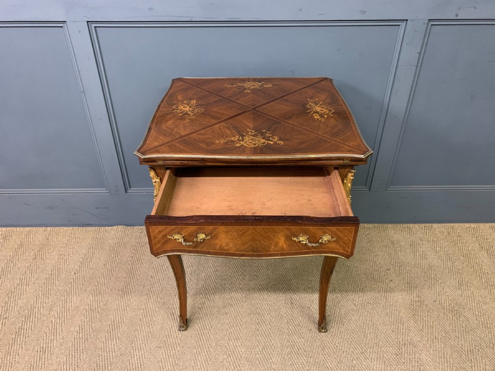 An Edwardian inlaid rosewood envelope card table featuring cabriole legs with brass mounts, a single drawer, and top flaps decorated with floral and musical instrument marquetry. View XI