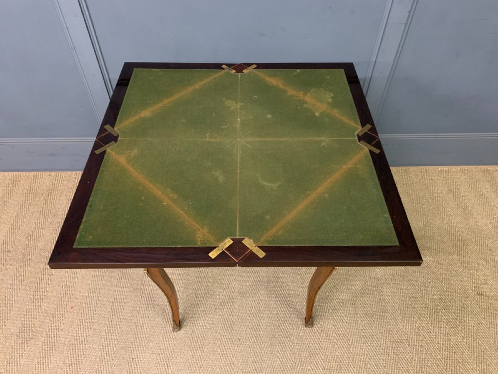 An Edwardian inlaid rosewood envelope card table featuring cabriole legs with brass mounts, a single drawer, and top flaps decorated with floral and musical instrument marquetry. View XVII