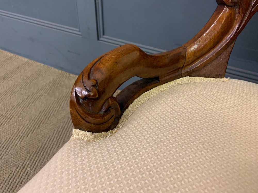 A Victorian walnut salon chair featuring a button-tufted cream backrest, carved wooden frame, cabriole front legs, and ceramic castors. View VIII