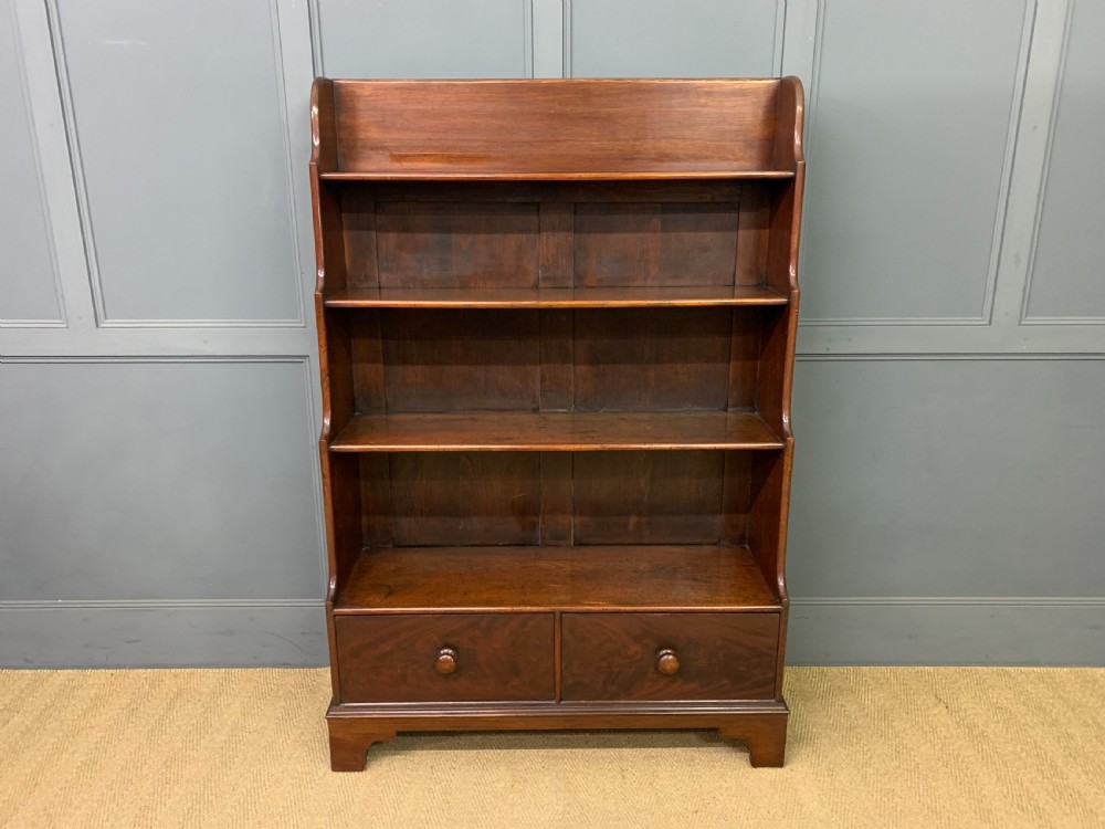 Victorian mahogany waterfall open bookcase featuring graduated shelves, shaped sides, and two lower drawers with turned wooden handles. View II
