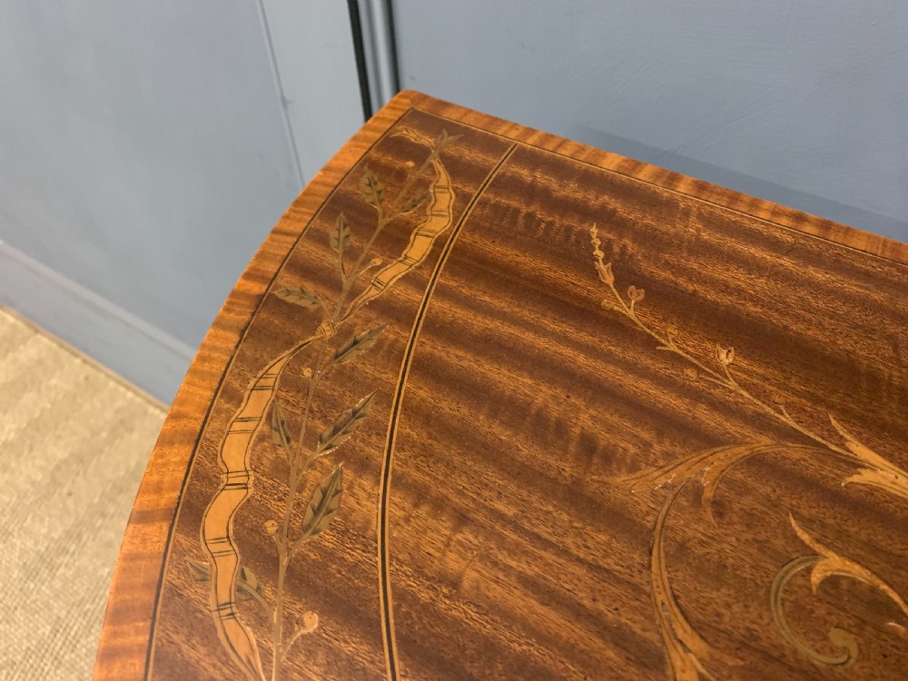 A demilune mahogany card table with floral marquetry inlays on the fold-over top and four square tapered legs. View V