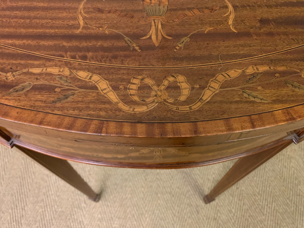 A demilune mahogany card table with floral marquetry inlays on the fold-over top and four square tapered legs. View VI