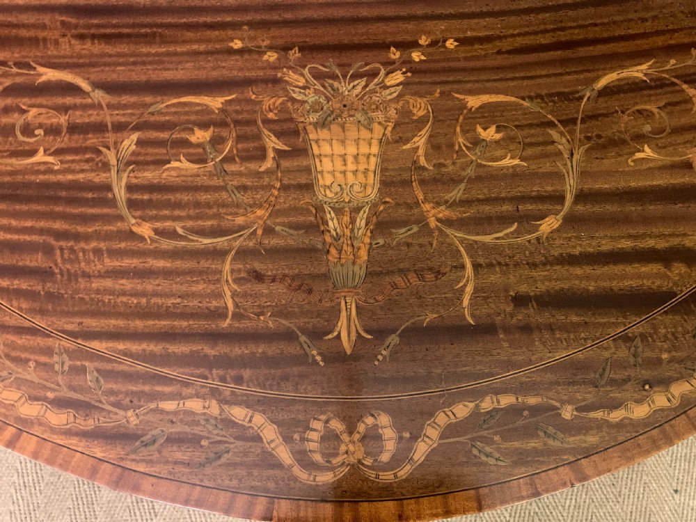 A demilune mahogany card table with floral marquetry inlays on the fold-over top and four square tapered legs. View VII