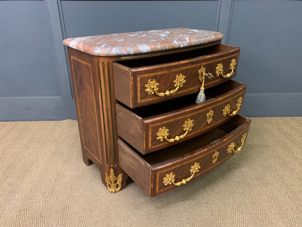 A French Louis XV style kingwood commode featuring three drawers, gilded metal mounts, and a variegated pink marble top. View XI
