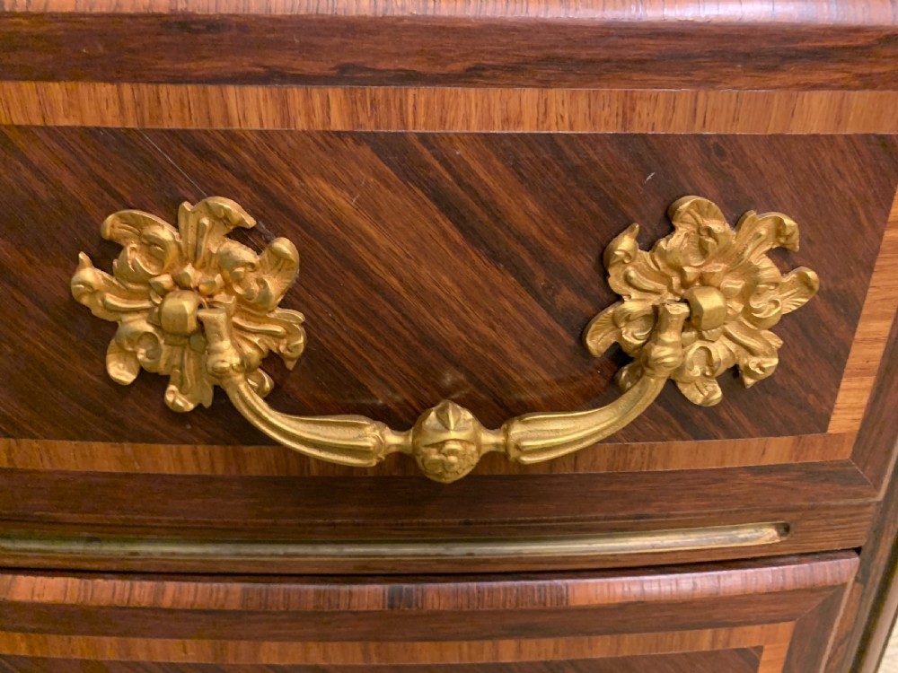 A French Louis XV style kingwood commode featuring three drawers, gilded metal mounts, and a variegated pink marble top. View XIV