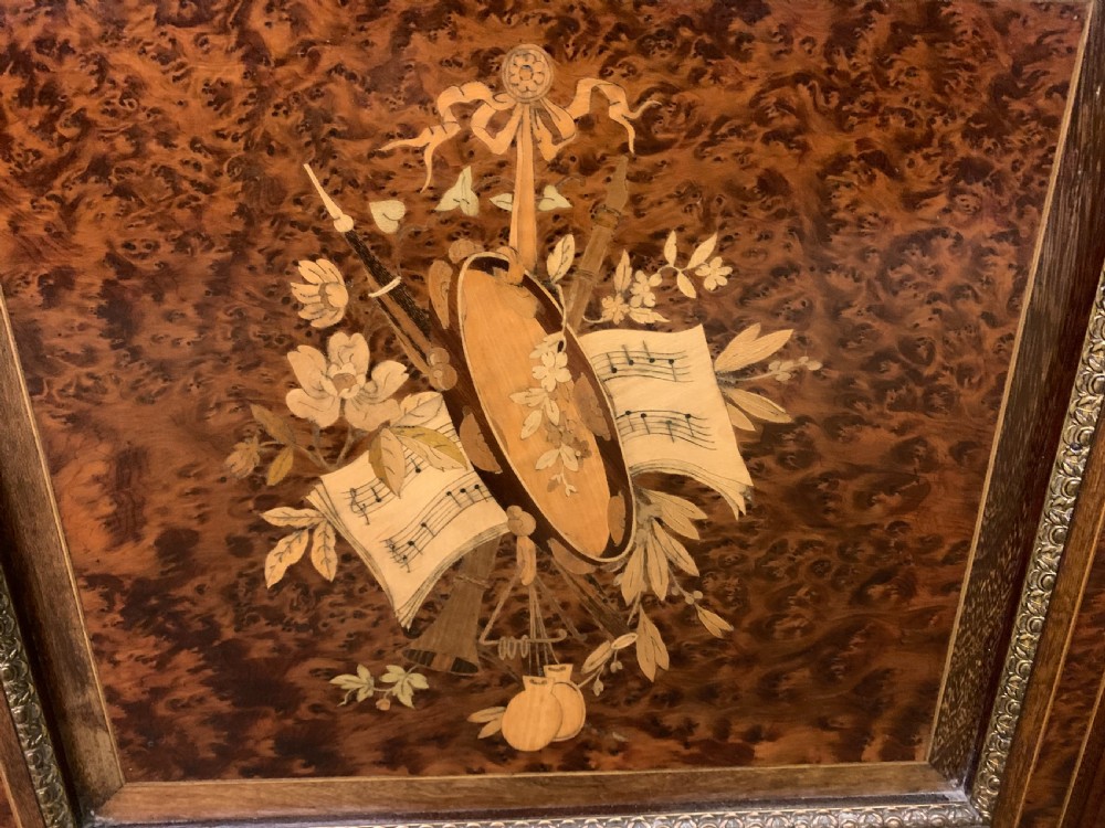 A 19th-century French double-door bookcase featuring amboyna and mahogany veneers, intricate floral marquetry, pleated cream fabric door panels, and brass mounts. View VII