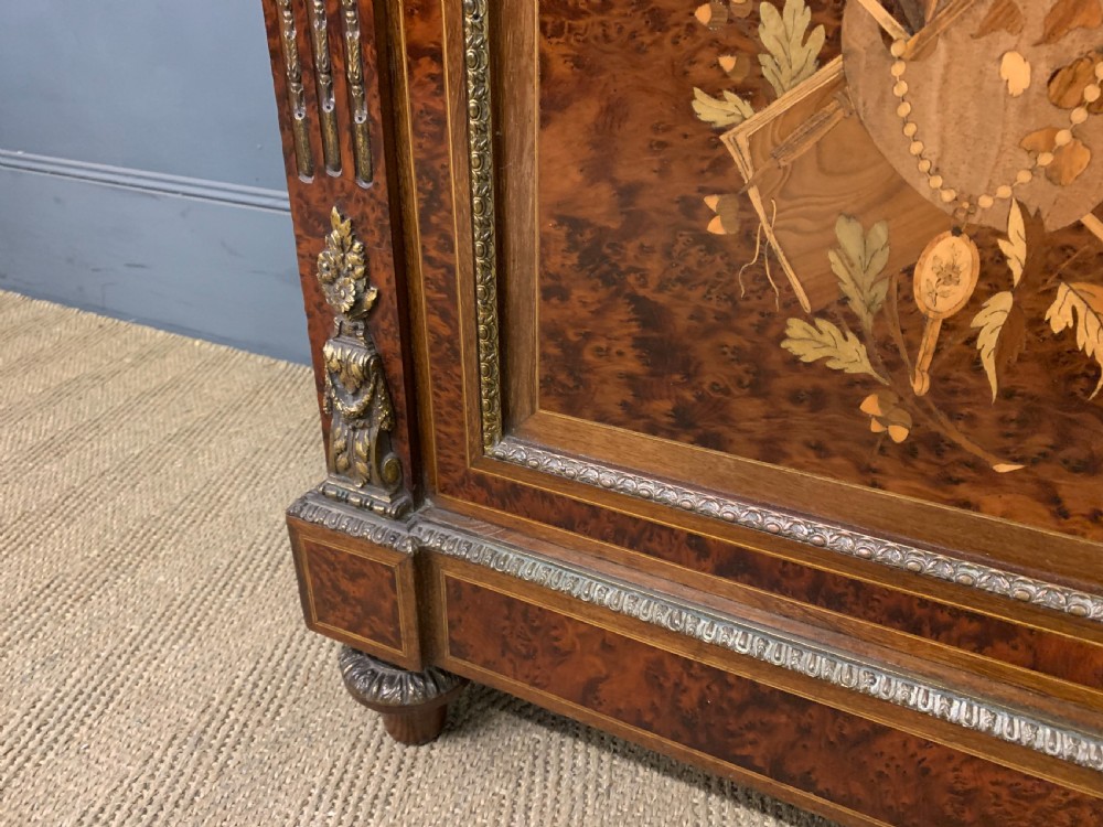A 19th-century French double-door bookcase featuring amboyna and mahogany veneers, intricate floral marquetry, pleated cream fabric door panels, and brass mounts. View VIII