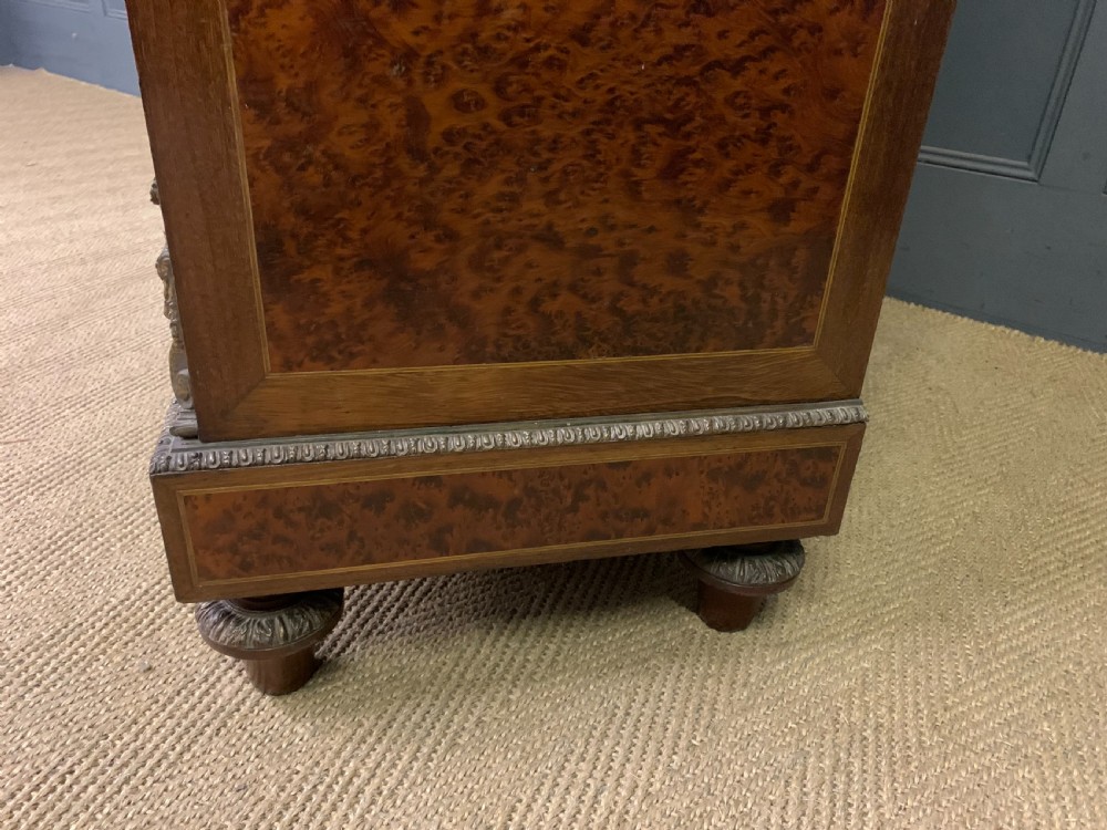A 19th-century French double-door bookcase featuring amboyna and mahogany veneers, intricate floral marquetry, pleated cream fabric door panels, and brass mounts. View XVIII
