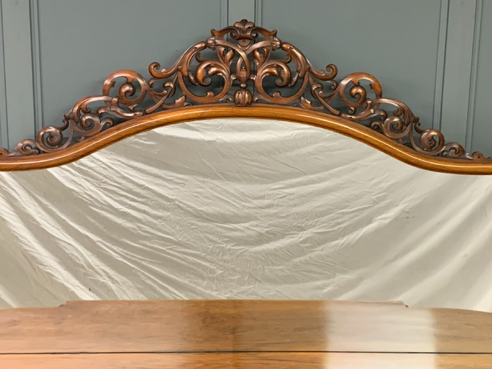 A Victorian burr walnut chiffonier featuring open side display shelves, mirrored central cabinet doors, and an ornate carved mirror frame cresting. View VII