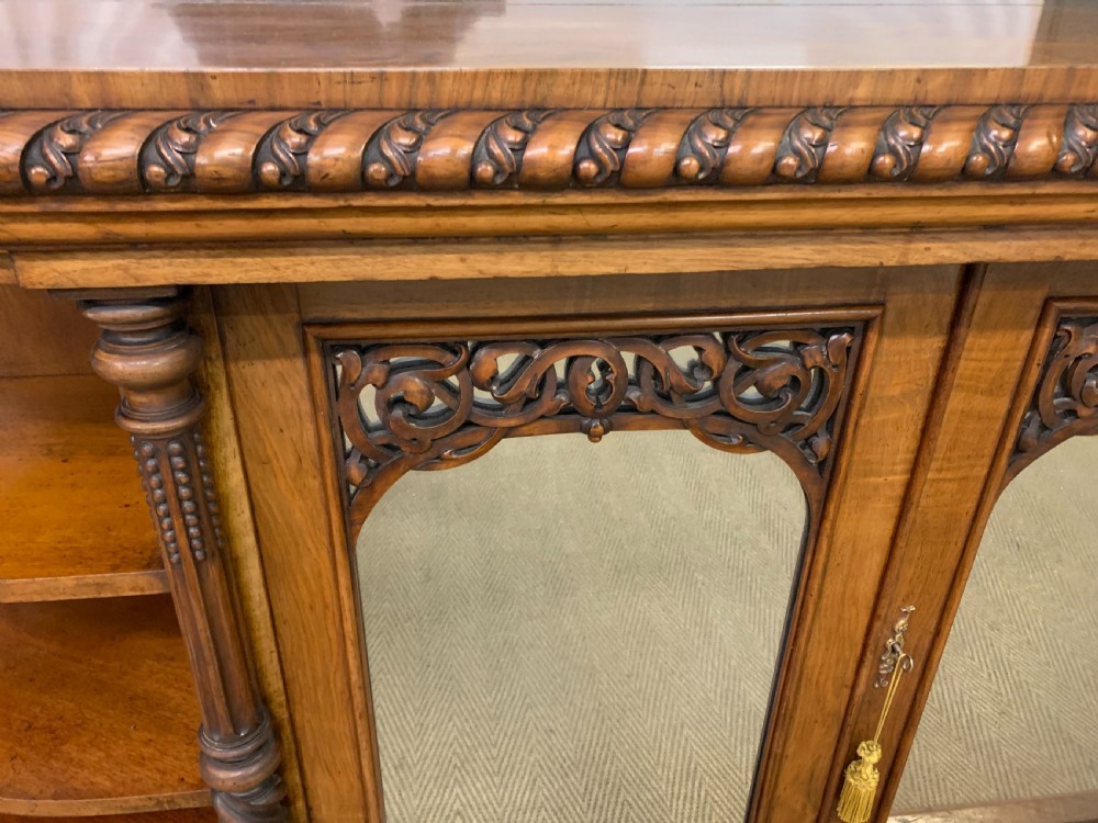 A Victorian burr walnut chiffonier featuring open side display shelves, mirrored central cabinet doors, and an ornate carved mirror frame cresting. View XII
